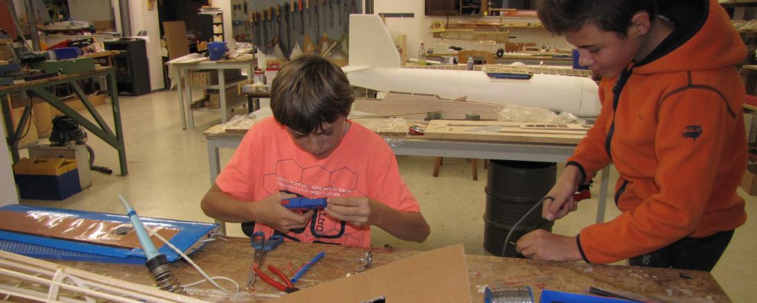 Das Bild zeigt Jugendlichen in der Jugendwerkstatt der Flugmodellgruppe beim Bauen von Modellfliegern