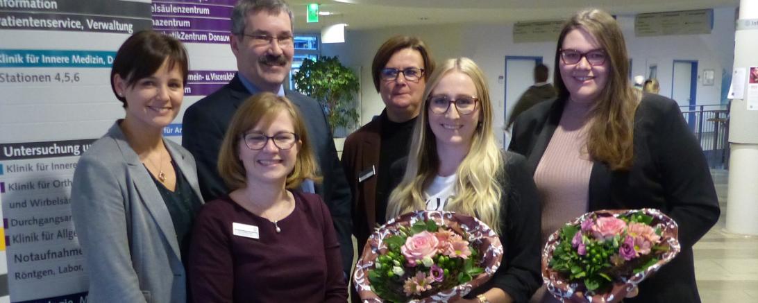 Das Bild zeigt zwei junge Gesundheits- und Krankenpflegerinnen aus den Donau-Ries Kliniken, die die Bachelor-Prüfung bestanden haben.