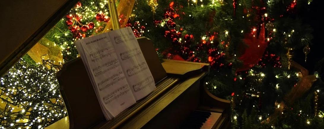 Das Bild zeigt ein Klavier mit einem Weihnachtsbaum