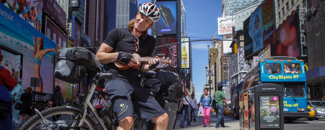 Dr. Dirk Rohrbach mit Fahrrad und Ukulele am Times Square in New York