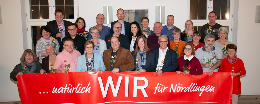 SPD-kandidaten mit Rose hinter einem SPD-Banner