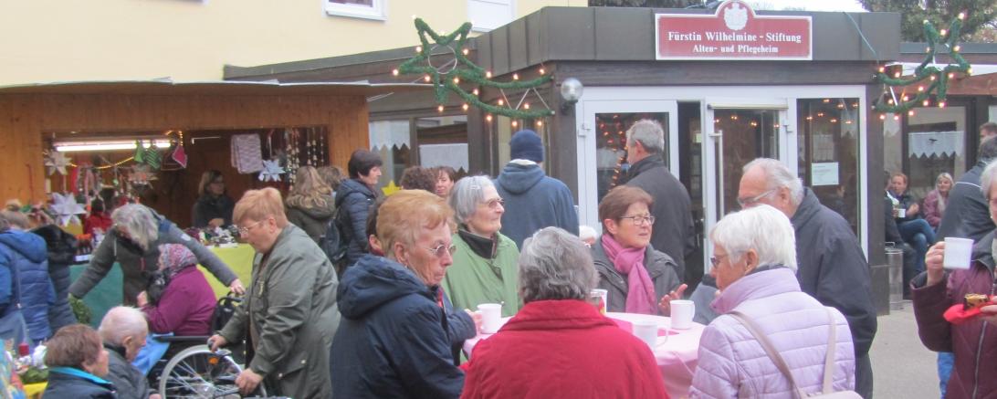 Menschen beim Adventsmarkt vor der Fürstin Wilhelmine Stiftung