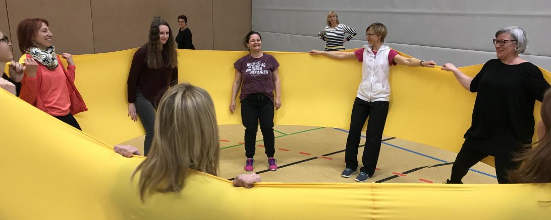 Frauen turnen mit gelbem Band