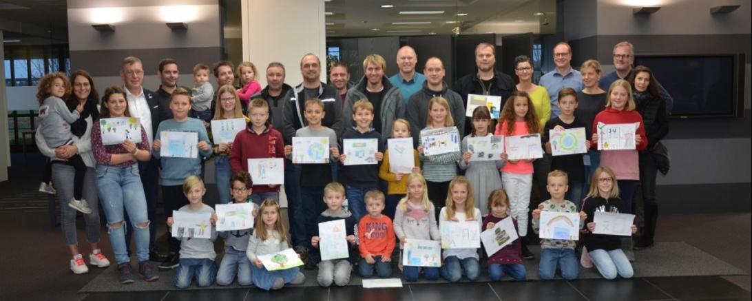 Die Kinder präsentieren stolz ihre kreativen Bilder vor den Eltern, der Werkleitung und dem Betriebsrat.  