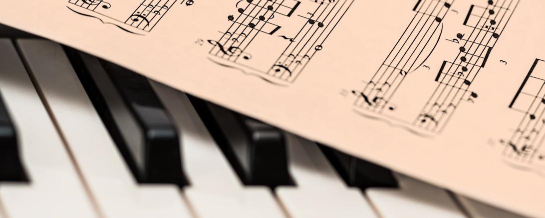 Das Bild zeigt Klaviertasten und Noten.