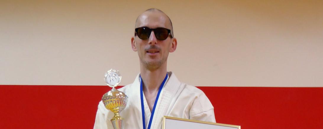 Rene Steinhübel im Keikogi mit Pokal und Urkunde