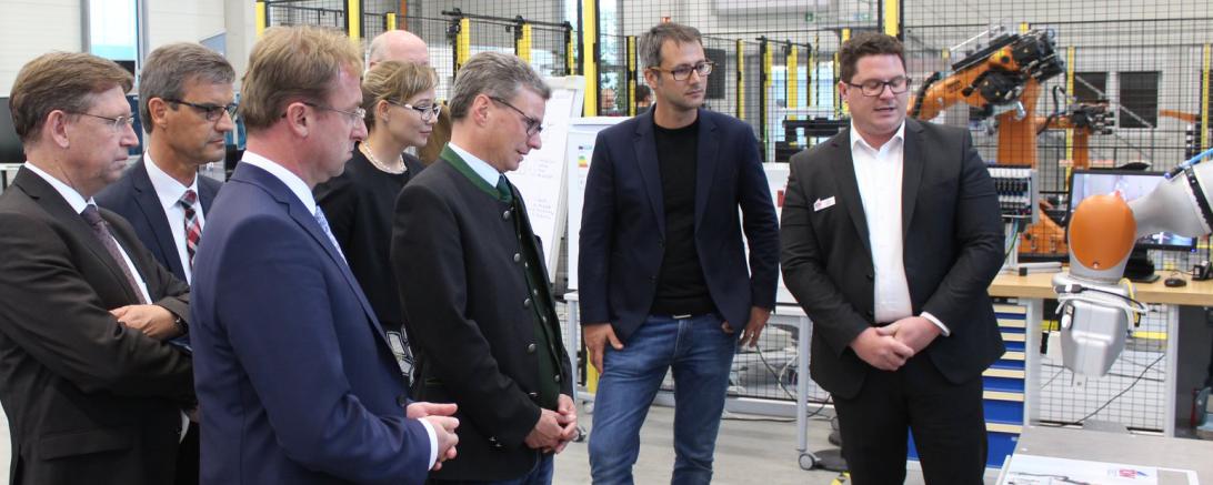 Das Bild zeigt OB-Kandidat Höhn mit Staatsminister Sibler, weiteren Vertretern der CSU und den Verantwortlichen des TCW beim Besuch der Roboterhalle.