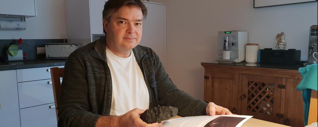 Mann mit Meteorit am Küchentisch