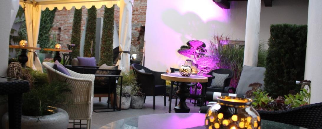 Das Bild zeigt den beleuchteten Innenhof der Mio Tagesbar.