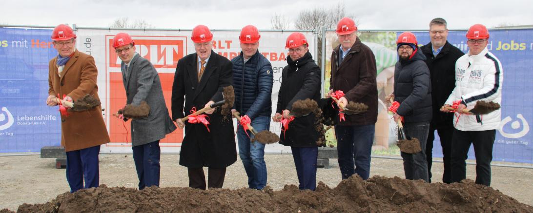 9 Männer mit Helm und Spaten schaufeln Erde