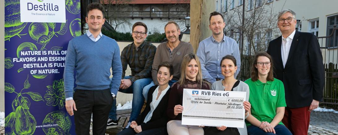Geschäftsführung und Mitarbeiter von Destilla mit Spendenscheck