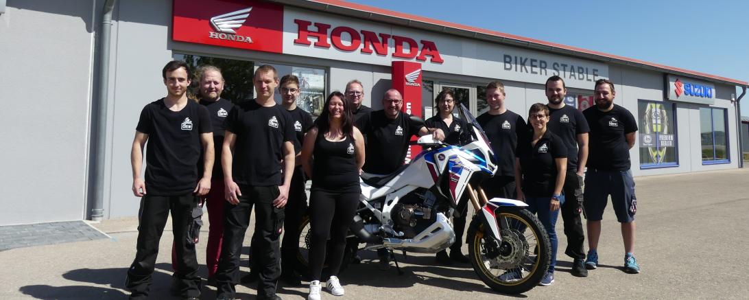 Menschen mit Motorrad vor Firmengebäude