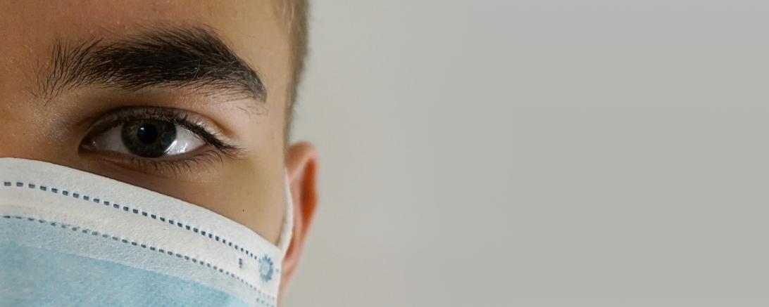 Halbes Gesicht eines Mannes mit Mundschutz