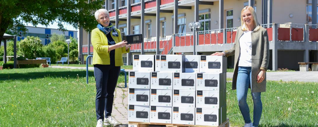 Zwei Frauen mit Palette voller Radios im Karton