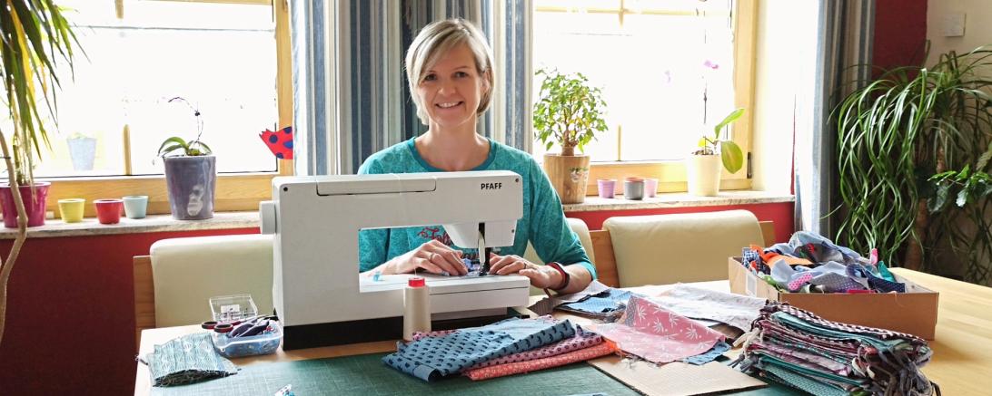 Das Bild zeigt Corina Karl an der Nähmaschine. 