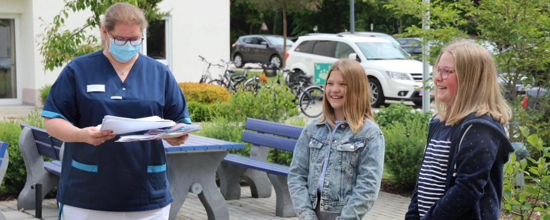 Altenpflegerin mit Mundschutz bekommt Briefe von zwei jungen Mädchen