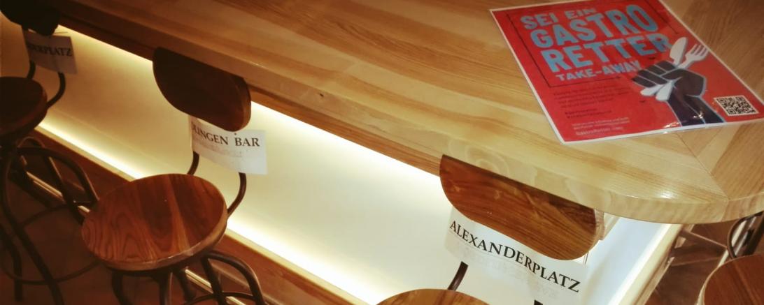 Stühle an Tresen mit Schild "Alexanderplatz"