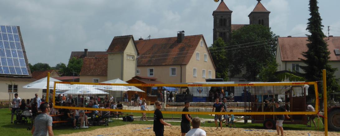 Beachvolleyballplatz mit Bewirtung in Auhausen, mit Kirche im Hintergrund