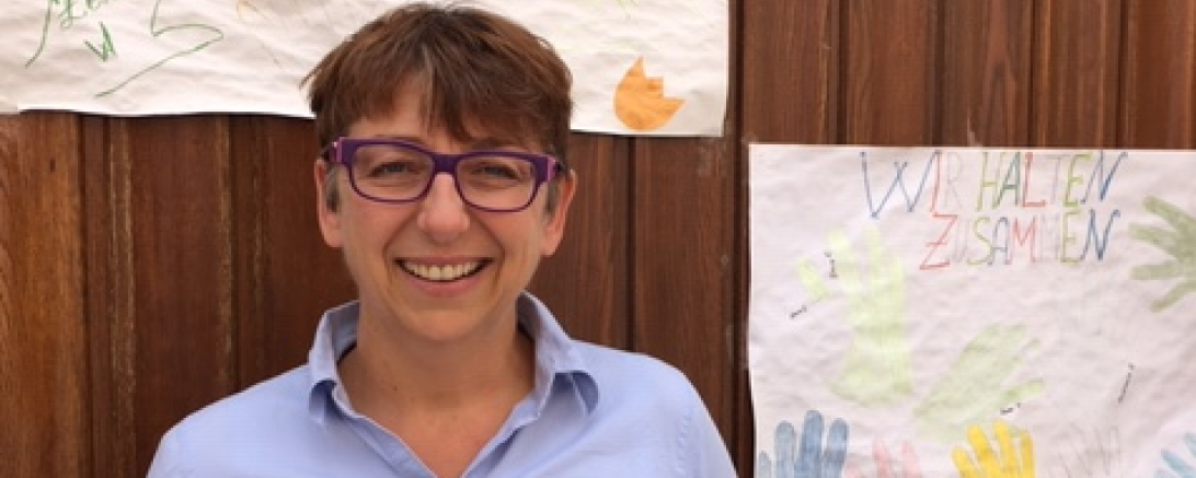 Claudia Riedelsheimer vor Wand mit Grußbotschaften