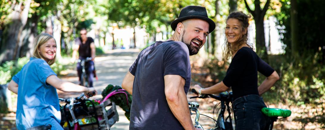 Personen mit Fahrrädern schauen in die Kamera