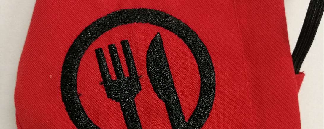 Rote Gesichtsmaske mit Messer-Gabel-Aufdruck