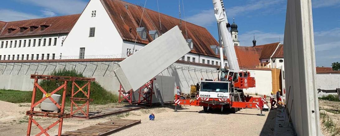 Auf der grünen Wiese vor der Anstalt baut das Staatliche Bauamt Augsburg am östlichen Ortsrand von Niederschönenfeld derzeit eine Torwache, ein Multifunktionsgebäude mit Wertstoffsammelstelle sowie ein Außenlager.