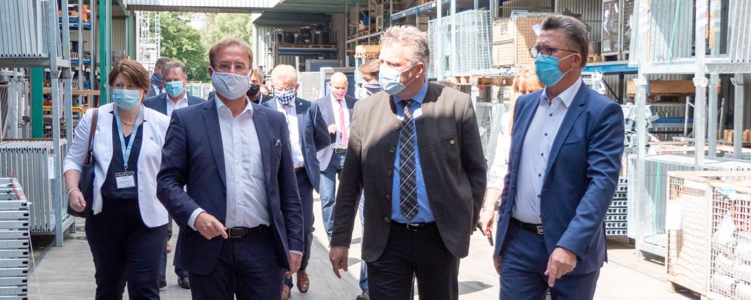 Personen mit Mundschutz erkunden Geda-Werk