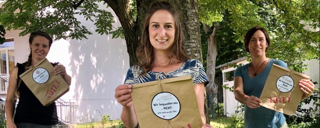 Drei Frauen mit Tüten vor einem Baum