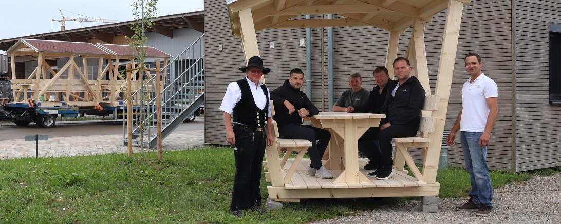 Männer in Holzpavillon vor Zimmerei Stark