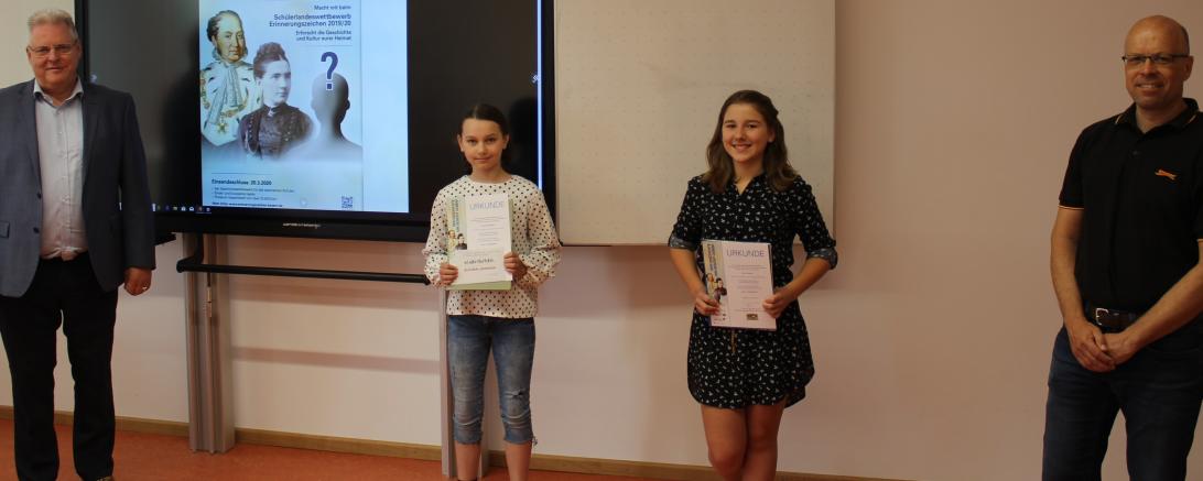 Zwei Männer und zwei Mädchen, Kinder mit Urkunden