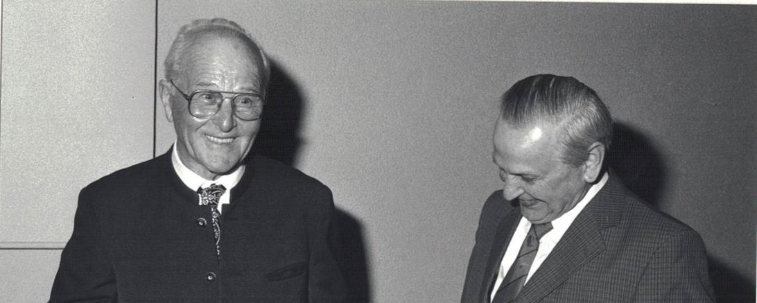 Schwarzweißaufnahme zweier älterer Herren, einer mit Meisterbrief