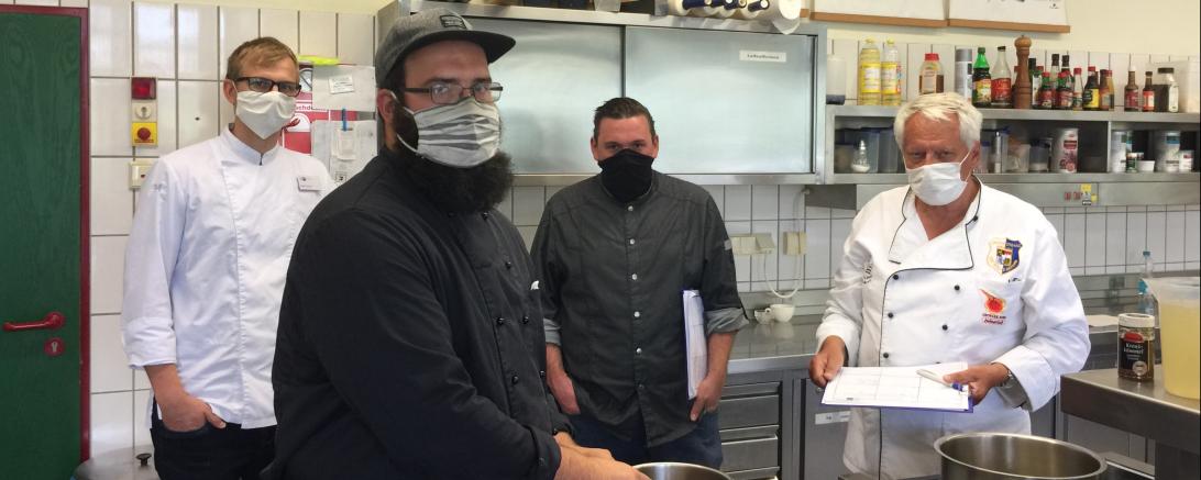 Vier Köche in der Küche, mit Masken