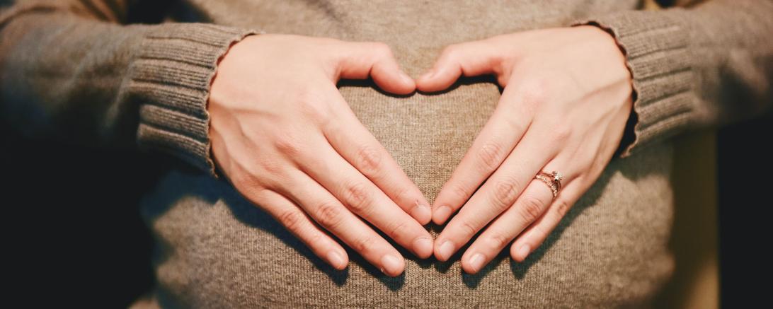 Hände auf Schwangerschaftsbauch