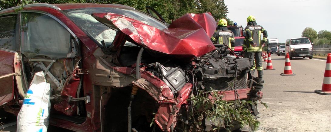 Zerstörtes rotes Auto auf Straße