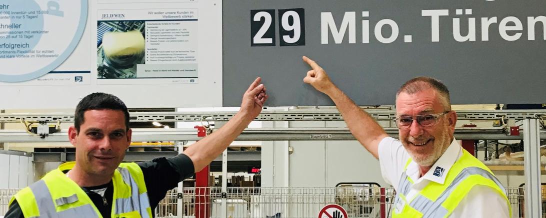 Zwei Herren in Warnwesten zeigen auf Zahl 29