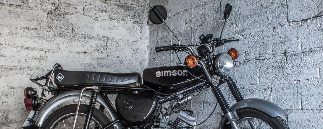 Moped vor grauer Wand