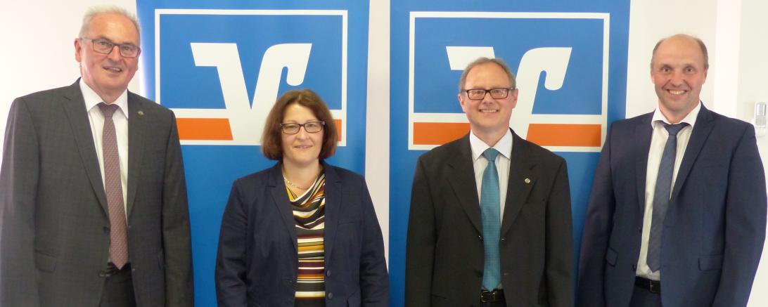 Eine Dame und drei Herren stehen vor RVB-Roll-ups