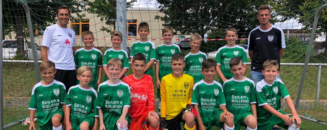 Junioren-Fußballmannschaft mit zwei Trainern