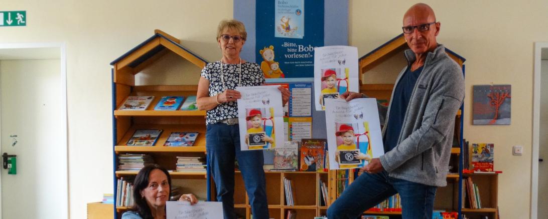 Bibliotheksleiterin Evelyn Leippert-Kutzner (sitzend) mit Inge Ordemann und Karl Kammer vom Kiwanis Club Donauwörth bei der Übergabe der Gutscheine für den Leseausweis für Erstklässler.