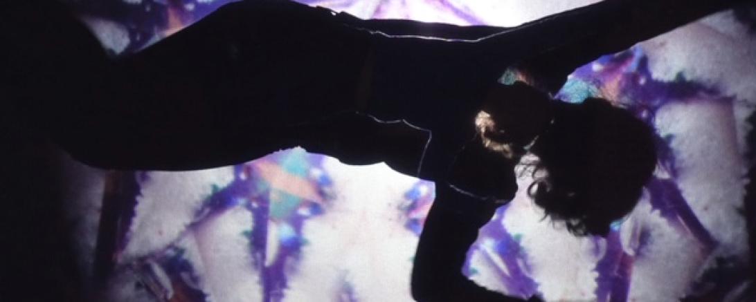 Das Bild zeigt eine Frau beim Malen mit Sand