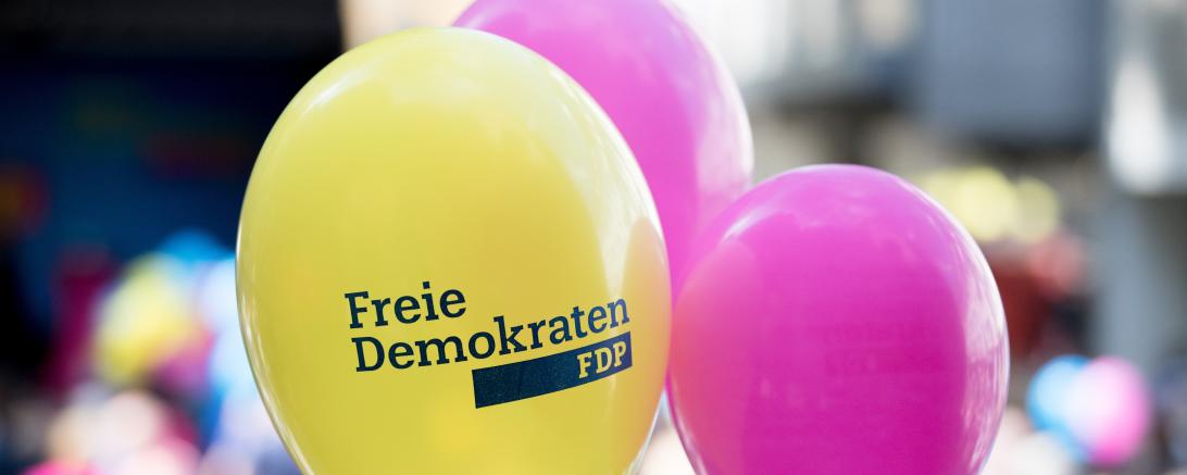 Drei Luftballons, zwei in magenta, einer gelb mit Aufdruck "Freie Demokraten FDP"