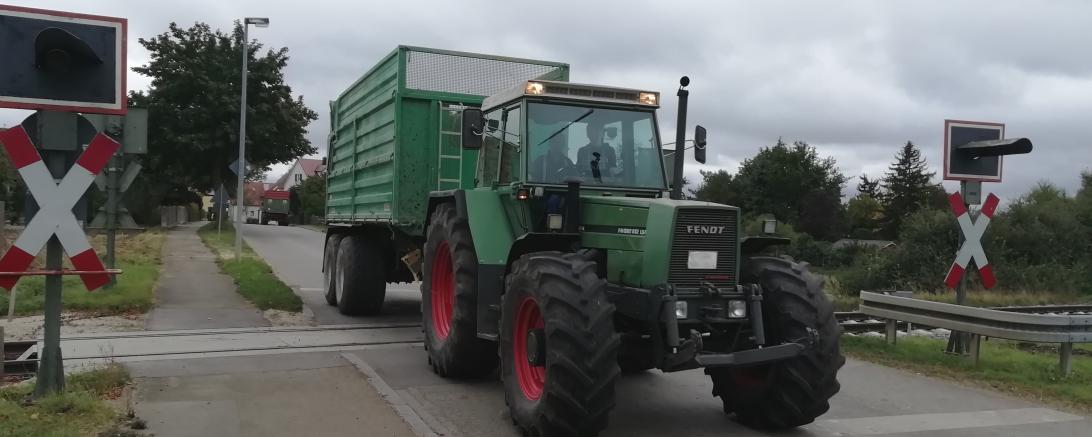 Traktor mit Anhänger überquert Bahnübergang Dürrenzimmern