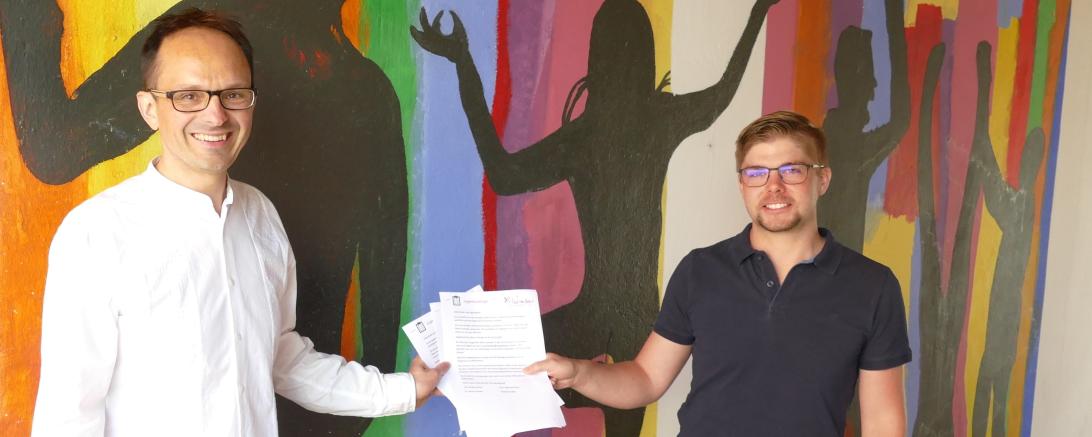 Dr. Drexler und Alexander Biber vor bunt bemalter Wand