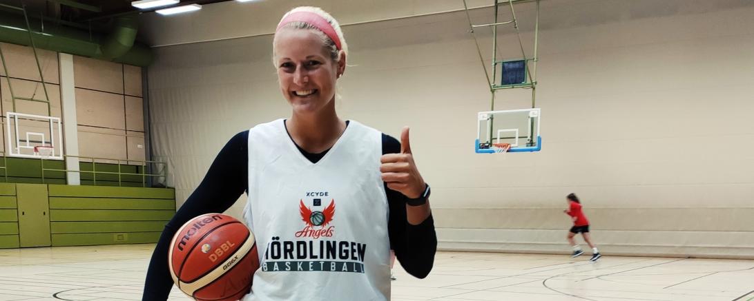 Baketballspielerin mit Ball in Turnhalle