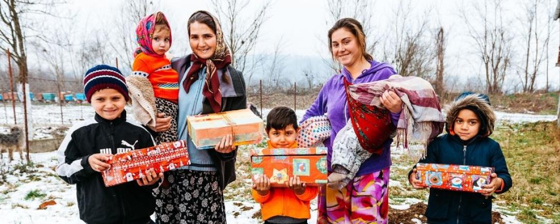 Das Bild zeigt eine Familie in Rumänien, die Weihnachtsgeschenke durch die Organisation Samaritan’s Purse bekommen hat.