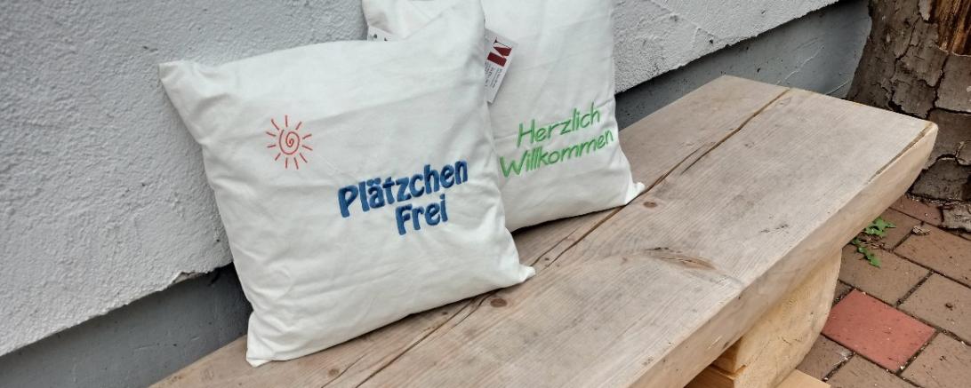 Zwei Kissen auf einer Holzbank