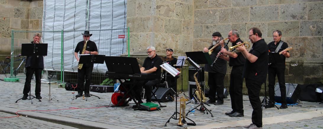 Das Bild zeigt die acht Musiker der Stadtjazzerey vor St Georg in Nördlingen.