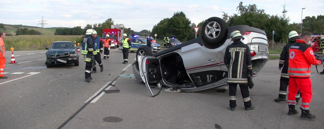 Rettungskräfte an Unfallort mit zwei Autos auf Straße