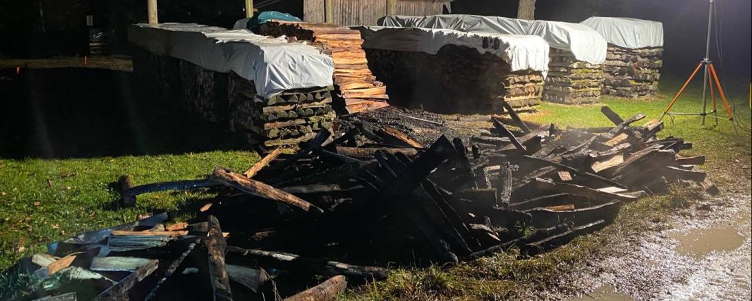 Angebrannte Bretter liegen im Dreck