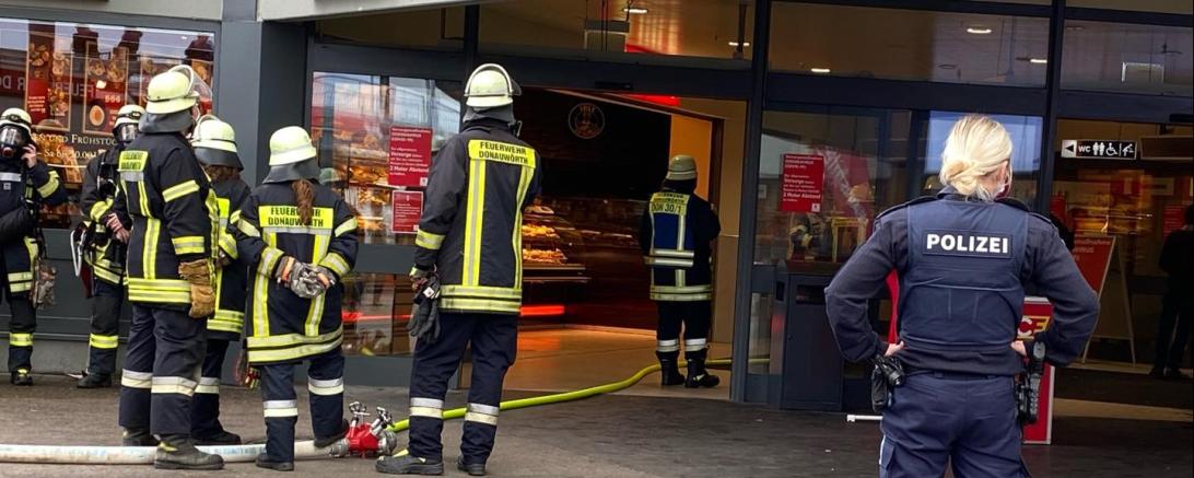 Polizistin und Feuerwehrleute vor Kaufland-Eingang
